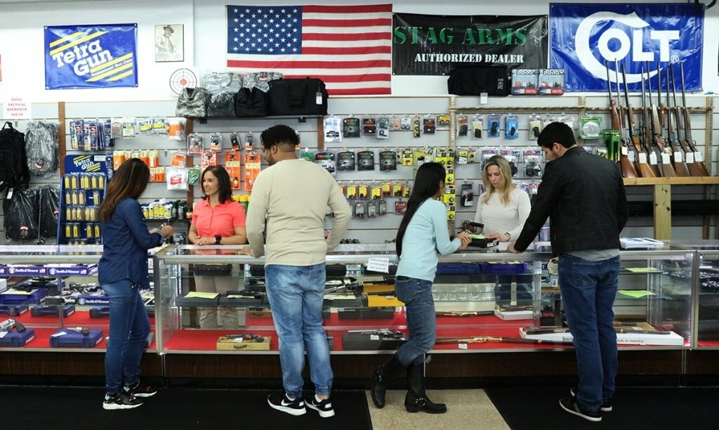 Turner's Outdoorsman storefront with Mossberg shotgun and pistol displayed, symbolizing legal firearm sales in California